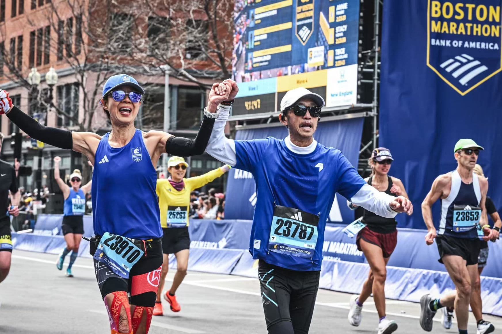 Two runners crossing Boston Marathon finish line