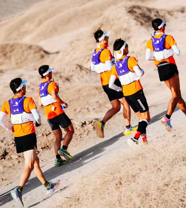 Team climbing desert slopes in the Gobi